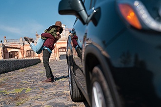 Dos personas abrazandose protegias con seguro de vida disfrutando su Chevrolet negro