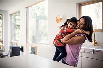 Madre e hija felices abrazándose en casa felices